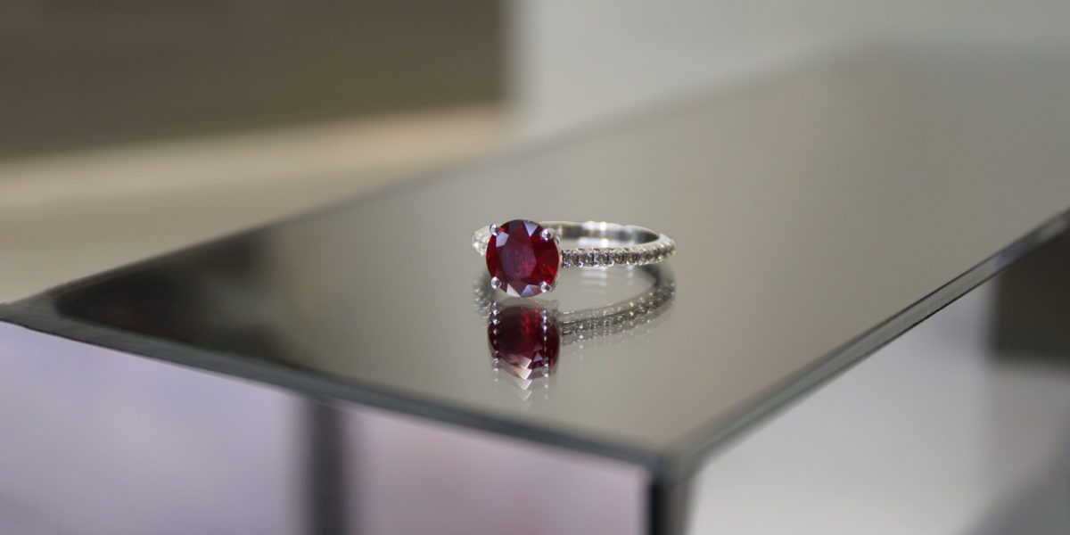 a close up of a Tiffany Novo Ruby ring on a table.